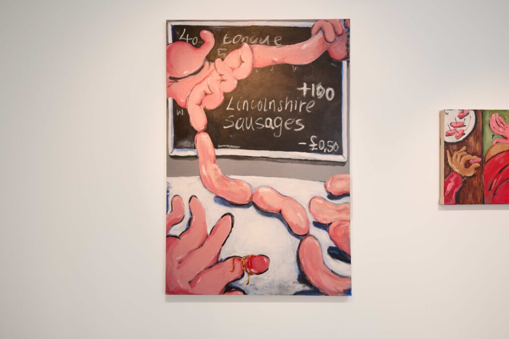 A colorful painting of pink sausages and a tongue in front of a chalkboard that reads "Tongue" and "Lincolnshire Sausages - £0.50," displayed on a white wall in an art gallery.