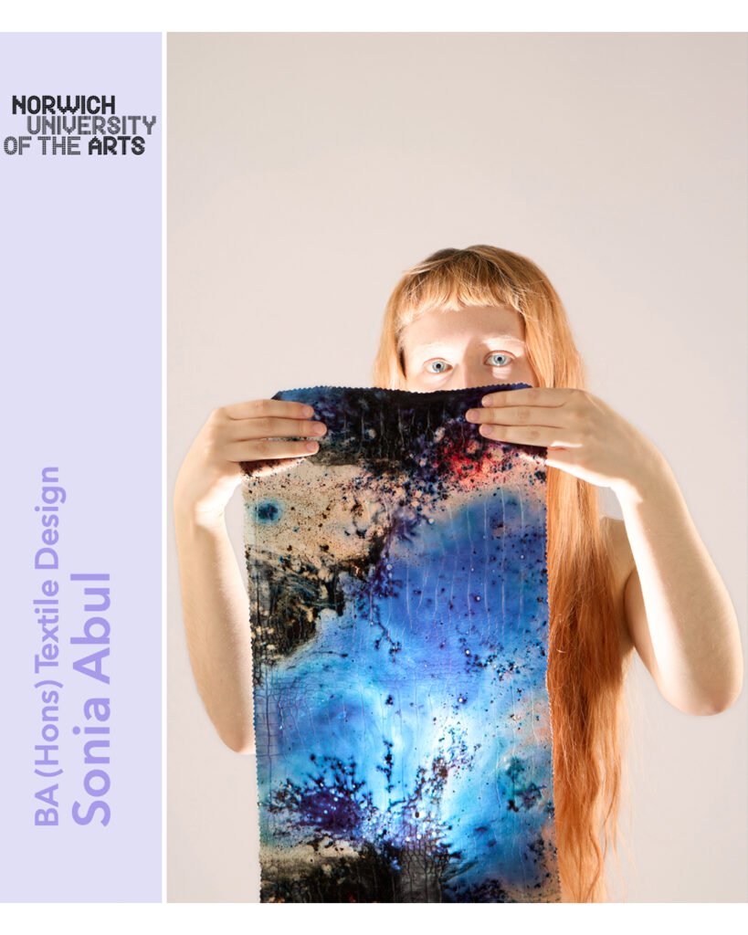 A person with long red hair holds up a vibrant textile artwork with blue, black, and white abstract patterns. Text reads "Norwich University of the Arts," "BA (Hons) Textile Design," and "Sonia Abul.