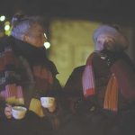 Still from BA Film and Moving Image Production Shirmaine Ong's film 'Till death to us Party' showing two people wrapped up in clothes drinking from a flask