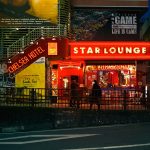 Image of a busy city street in Tokyo with shops with bright neon lights