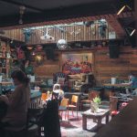 Gonzos Tea Room in Norwich, showing people sat between artefacts and glitter balls within the bar