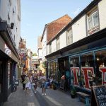 People walking down Lower Goat Lane and Biddys tea room with the words 'tea' in the windows at the Norwich Lanes Fair