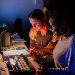 Two students at Norwich University of the Arts sit in the control room of the Sir John Hurt Film Studio