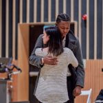 Two BA Acting students embrace solemnly on stage