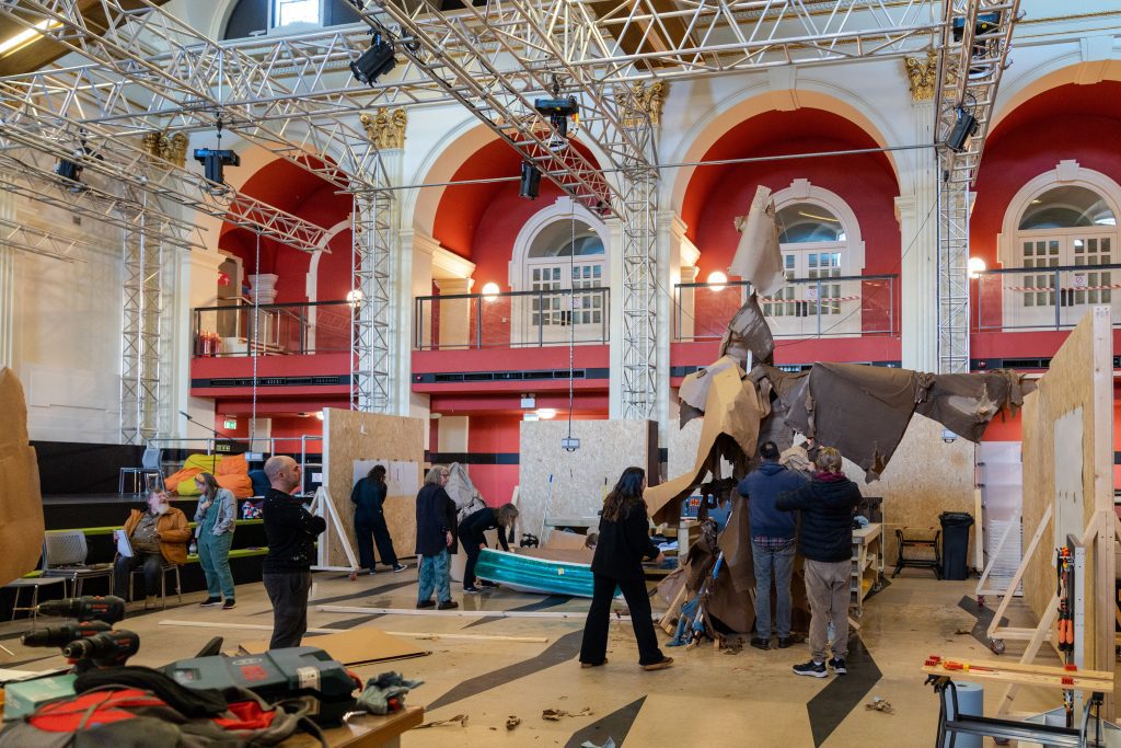 A photo in the banking hall of Bank Plain. The image is of several students working on a large cardboard sculpture.