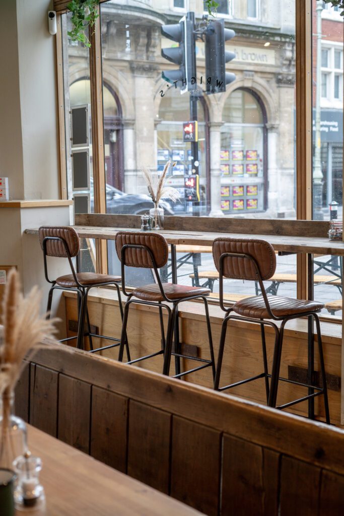 A photograph of some brown leather stools in a Norwich coffee shop.