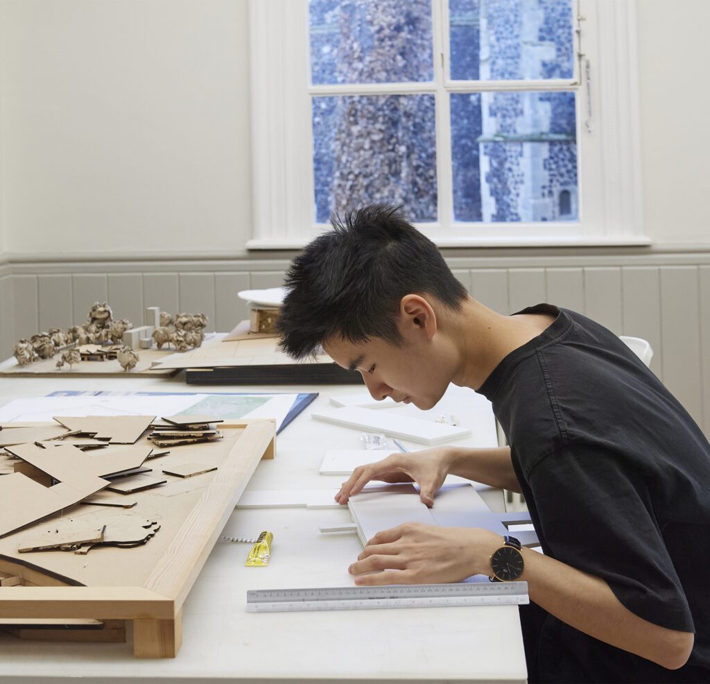 A photo of Desmond Lau, BA (Hons) Interior Design student working at a table.